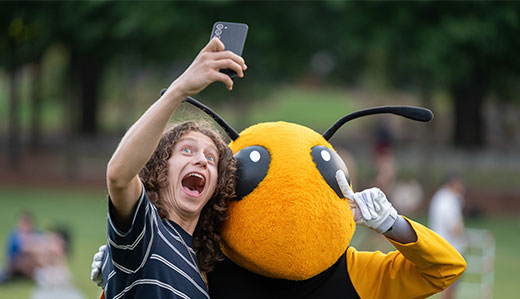  A student poses for a selfie with Buzz, Georgia Tech’s mascot.