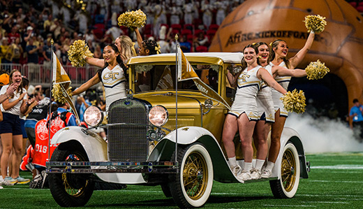 Georgia Tech cheerleaders ride the Ramblin’ Reck onto the football field.